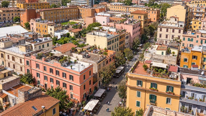Immagine generata: l’isola pedonale del Pigneto dall’alto, tetti di coppi, terrazzi e i tendoni dei locali